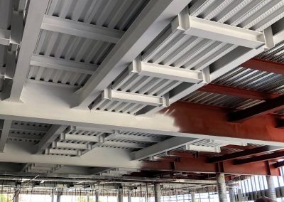 Vigas metálicas con pintura intumescente aplicada, mitad con imprimación y mitad terminadas
